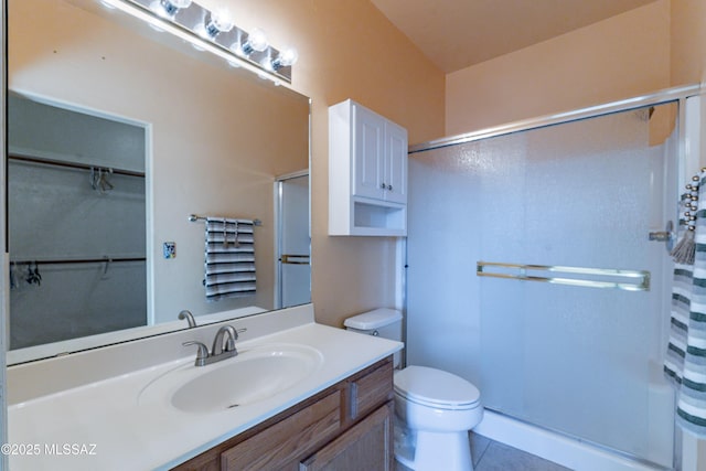 full bathroom featuring vanity, toilet, tile patterned flooring, and walk in shower