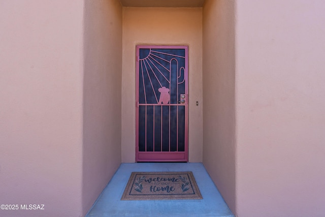 doorway to property featuring stucco siding