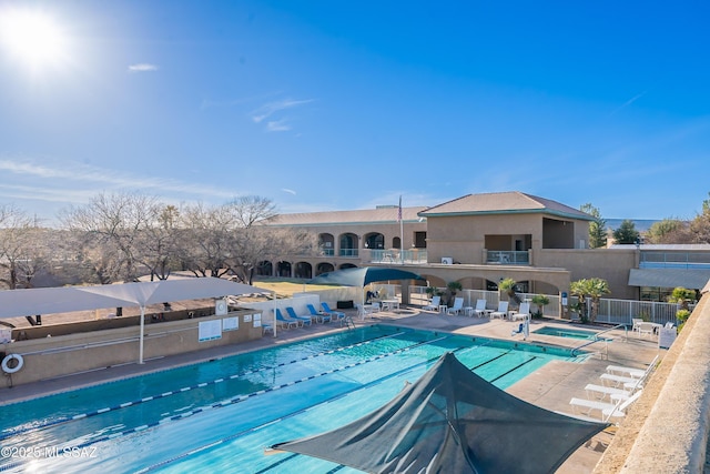 community pool featuring a patio and fence