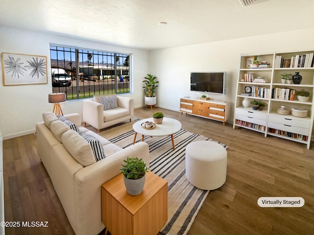 living area featuring baseboards and dark wood finished floors