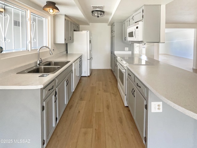 kitchen featuring sink, white appliances, and light hardwood / wood-style flooring