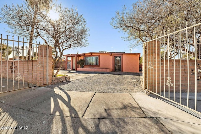 view of front of home featuring a fenced front yard, a gate, and stucco siding