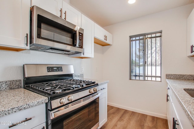 kitchen featuring light stone counters, white cabinets, and appliances with stainless steel finishes