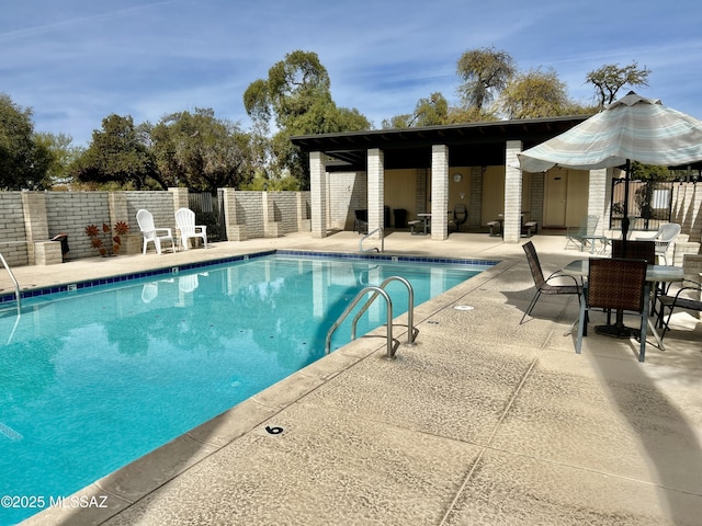 community pool with a fenced backyard and a patio