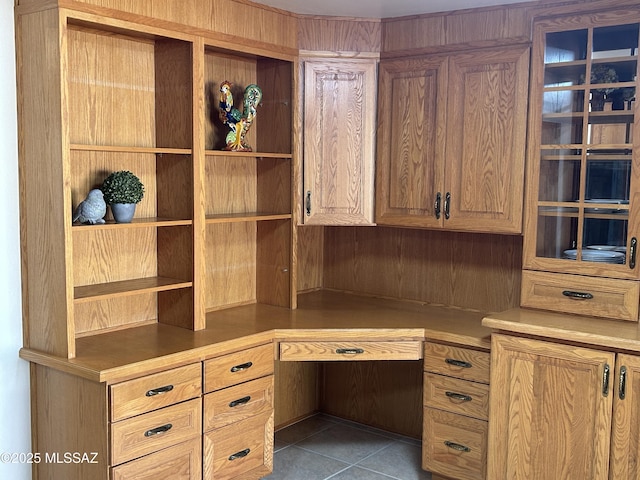 unfurnished office featuring built in study area and tile patterned floors