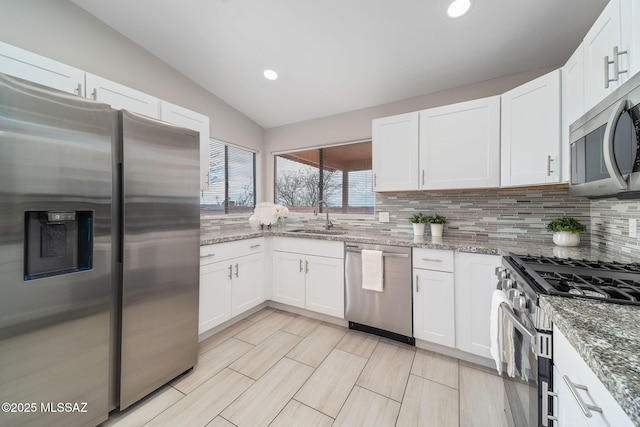 3098 S Giovanna Dr, Tucson, AZ 85730 - kitchen with appliances with stainless steel finishes, a sink, vaulted ceiling, tasteful backsplash, and white cabinetry