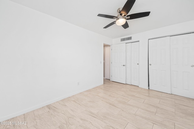 3098 S Giovanna Dr, Tucson, AZ 85730 - unfurnished bedroom with multiple closets, ceiling fan, and baseboards