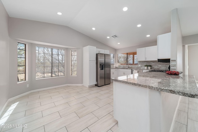 3098 S Giovanna Dr, Tucson, AZ 85730 - kitchen featuring stainless steel appliances, light stone countertops, a peninsula, vaulted ceiling, and white cabinets