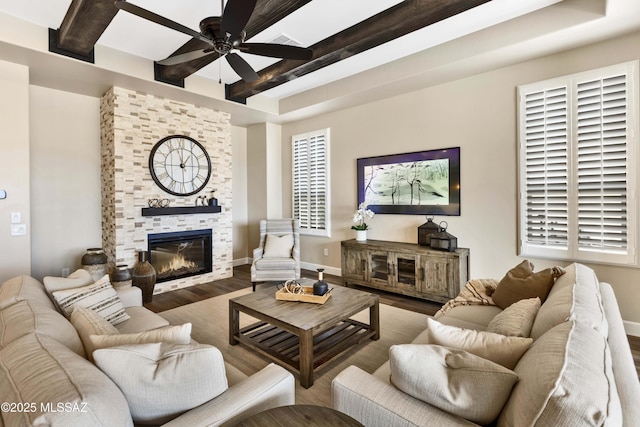 living room featuring a fireplace, beamed ceiling, ceiling fan, and hardwood / wood-style floors