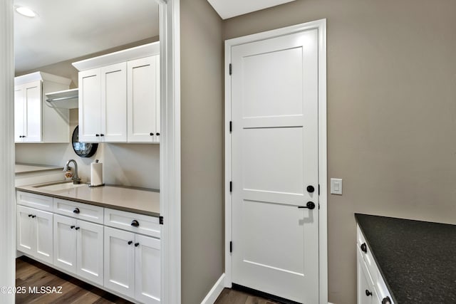 kitchen with white cabinetry, sink, and dark hardwood / wood-style flooring