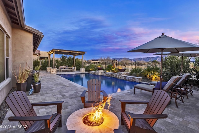 pool at dusk featuring a patio area and an outdoor fire pit