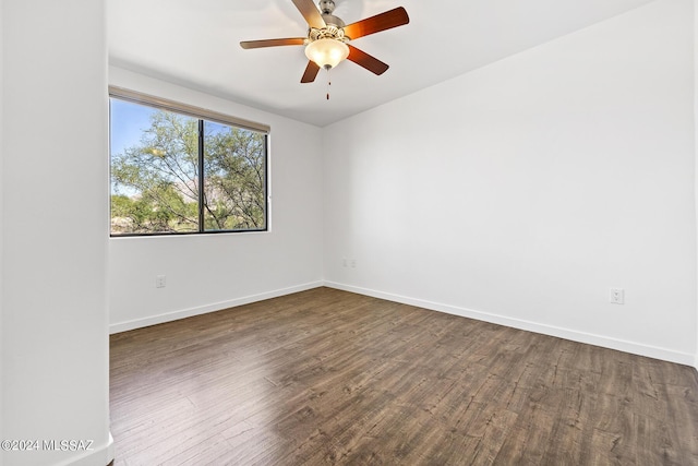 spare room featuring dark wood-type flooring and ceiling fan