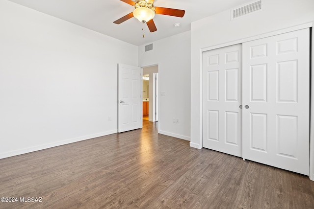 unfurnished bedroom with hardwood / wood-style flooring, ceiling fan, and a closet