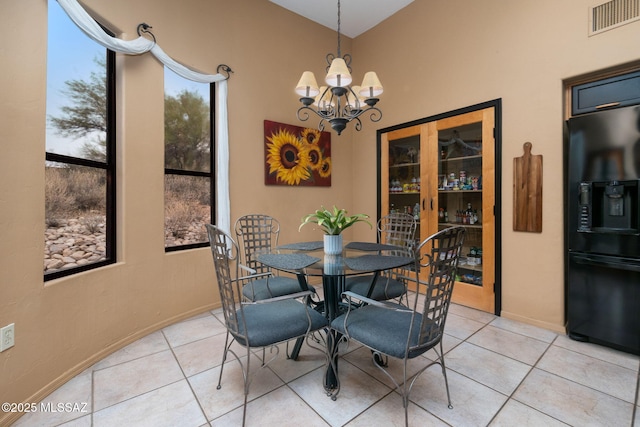 dining space featuring light tile patterned flooring and an inviting chandelier