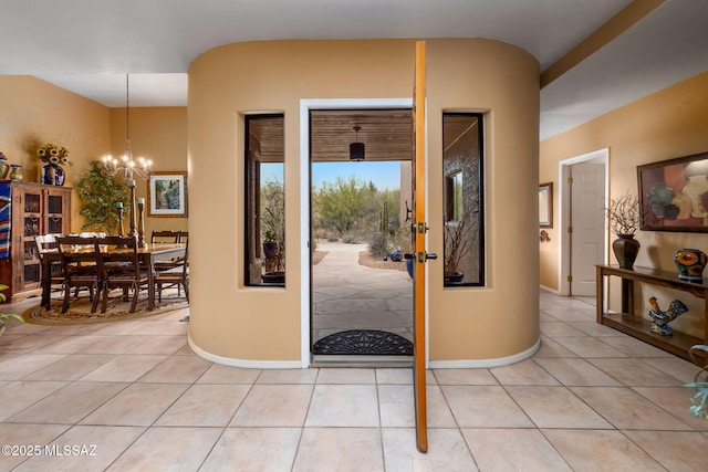 foyer entrance with light tile patterned flooring and a notable chandelier