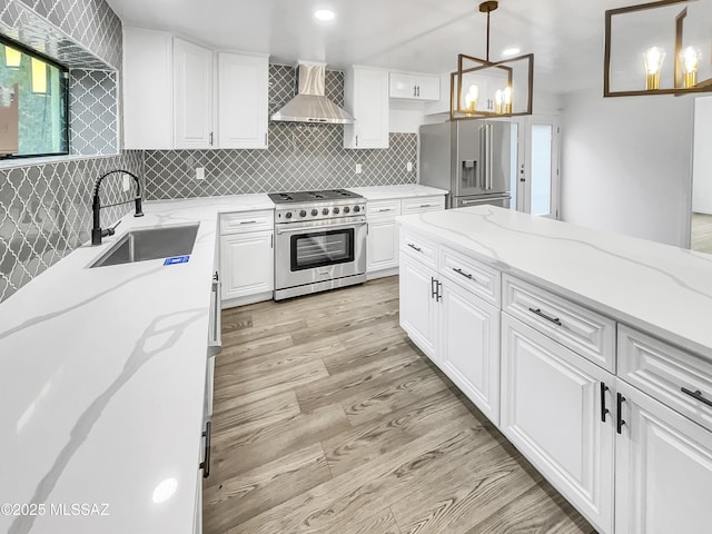 341 S Tucson Blvd, Tucson, AZ 85716 - kitchen with white cabinets, stainless steel appliances, a sink, light wood-type flooring, and wall chimney exhaust hood