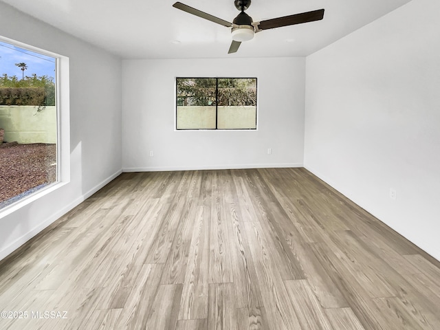 341 S Tucson Blvd, Tucson, AZ 85716 - unfurnished room featuring plenty of natural light, a ceiling fan, wood finished floors, and baseboards