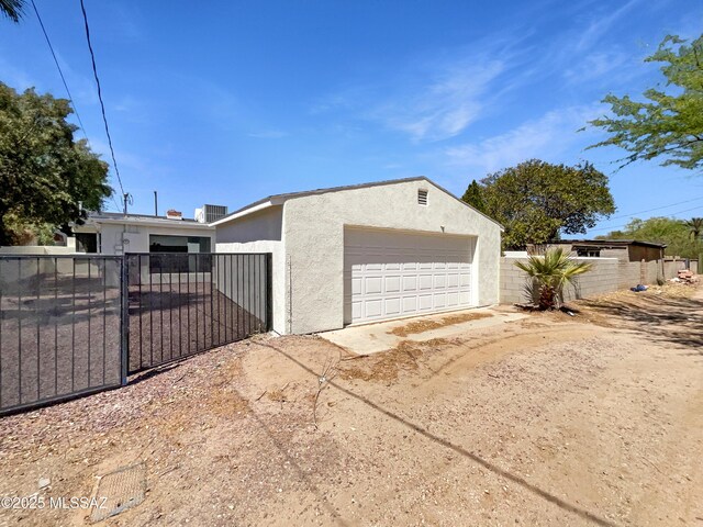 341 S Tucson Blvd, Tucson, AZ 85716 - view of side of home with fence, a gate, a detached garage, and stucco siding