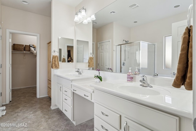 full bath featuring double vanity, a shower stall, a walk in closet, and a sink