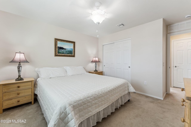 bedroom featuring a closet, visible vents, light colored carpet, and baseboards