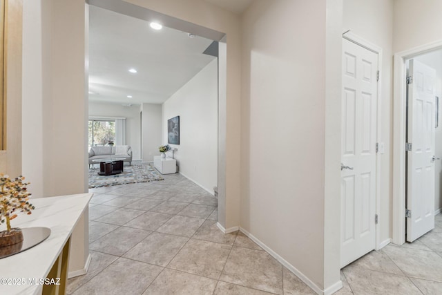 corridor with light tile patterned floors, recessed lighting, and baseboards