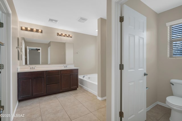 bathroom featuring tile patterned flooring, vanity, a washtub, and toilet