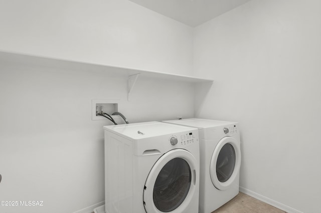 laundry area with light tile patterned floors and washing machine and clothes dryer