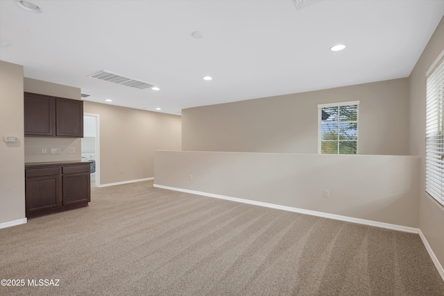 unfurnished room featuring light carpet