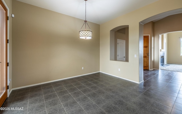 13289 E Wranglers Rest Dr, Vail, AZ 85641 - empty room with dark tile patterned flooring, baseboards, and arched walkways