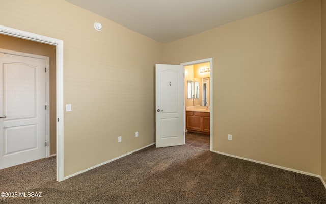 13289 E Wranglers Rest Dr, Vail, AZ 85641 - unfurnished bedroom with dark colored carpet, baseboards, and connected bathroom