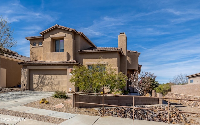 mediterranean / spanish house with a tile roof, a chimney, stucco siding, concrete driveway, and an attached garage