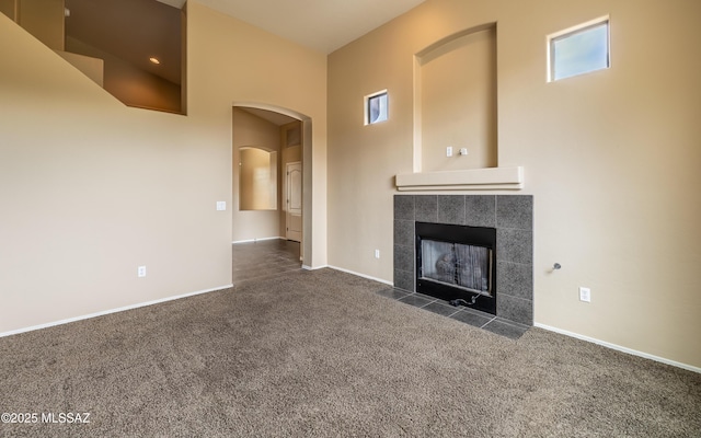 13289 E Wranglers Rest Dr, Vail, AZ 85641 - unfurnished living room featuring carpet flooring, arched walkways, a fireplace, and baseboards