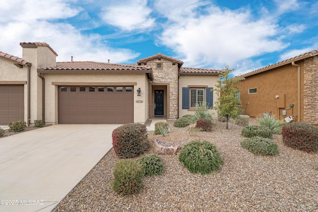 mediterranean / spanish-style house with driveway, stone siding, a tile roof, an attached garage, and stucco siding