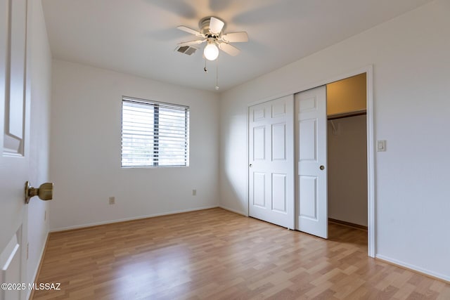 unfurnished bedroom with baseboards, visible vents, a closet, and light wood-style flooring