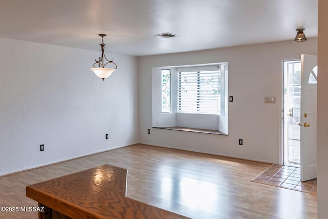 foyer with light wood-style flooring and visible vents