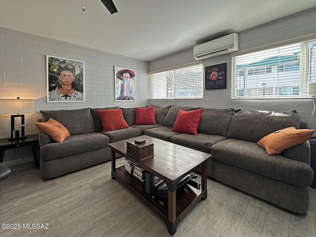 living room featuring a wall mounted AC and light hardwood / wood-style flooring