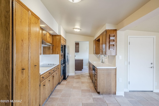 kitchen featuring sink, black electric stovetop, stainless steel microwave, and light tile patterned floors