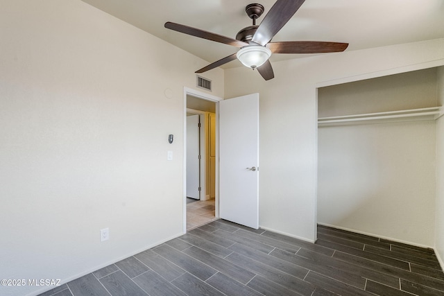 unfurnished bedroom with ceiling fan and a closet