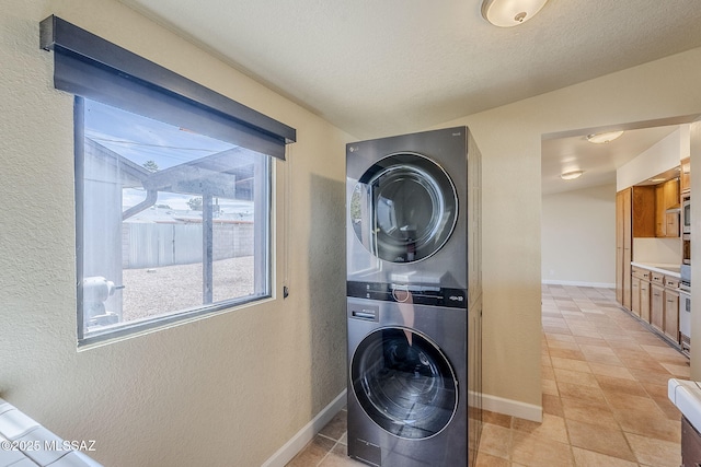 clothes washing area with stacked washer / dryer