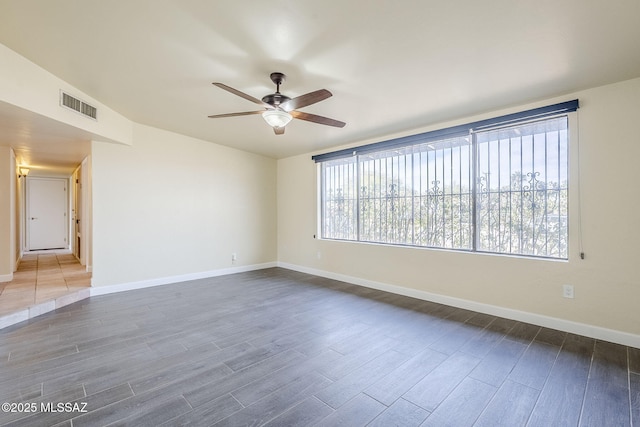 unfurnished room featuring dark wood-type flooring and ceiling fan