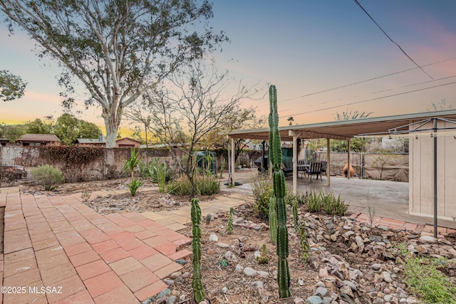 yard at dusk featuring a patio area