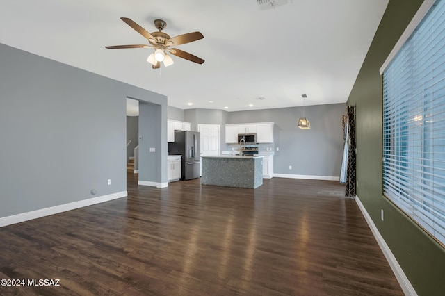 unfurnished living room with dark hardwood / wood-style floors and ceiling fan