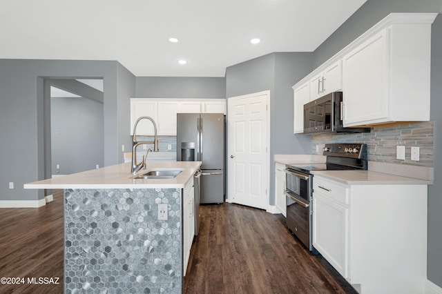 kitchen with stainless steel appliances, sink, white cabinets, and a kitchen island with sink