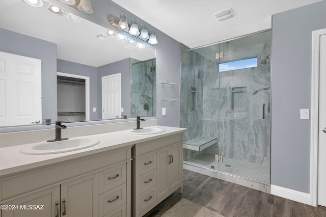 bathroom featuring hardwood / wood-style flooring, vanity, and a shower with door