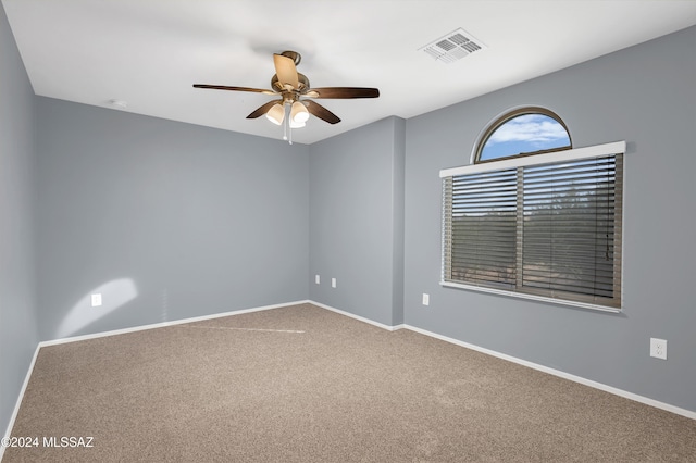 unfurnished room with ceiling fan and carpet