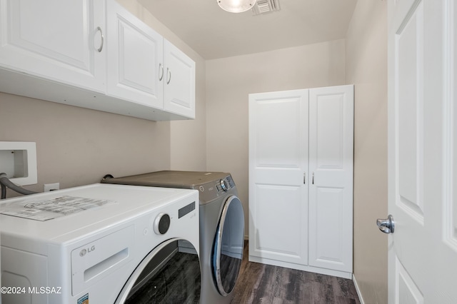 clothes washing area featuring cabinets, separate washer and dryer, and dark hardwood / wood-style flooring