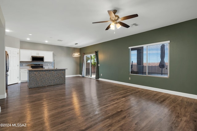 unfurnished living room featuring ceiling fan and dark hardwood / wood-style floors