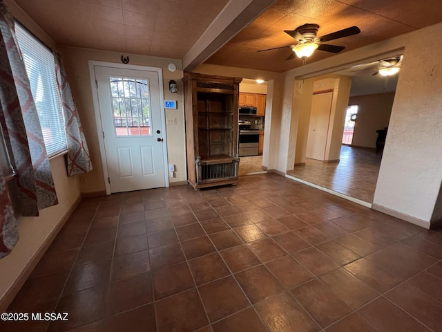 entrance foyer featuring dark tile patterned floors, baseboards, and a ceiling fan