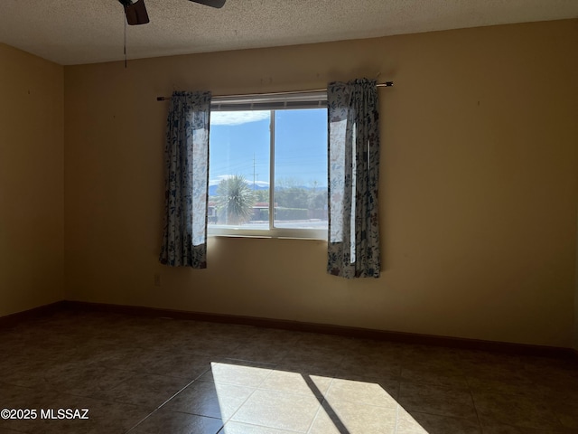 177 N Abrego Dr, Green Valley, AZ 85614 - empty room featuring baseboards, tile patterned floors, ceiling fan, and a textured ceiling