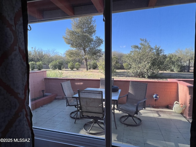 view of patio featuring outdoor dining area and fence